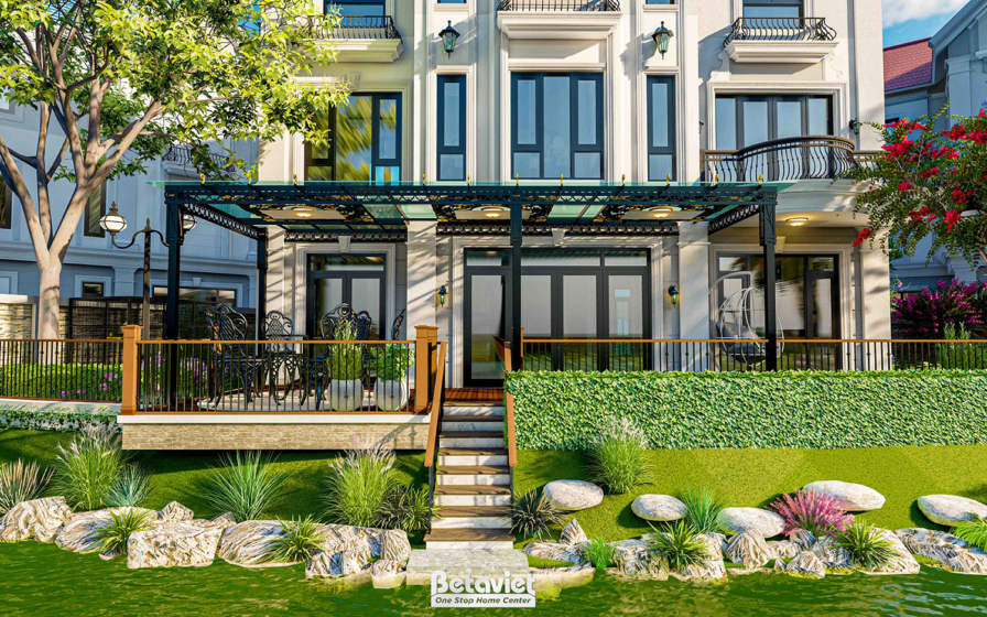 Góc sân trước biệt thự ban ngày với mái hiên pergola khung sắt đen lợp kính, sàn gỗ và bậc thang dẫn xuống thảm cỏ, tiểu c…