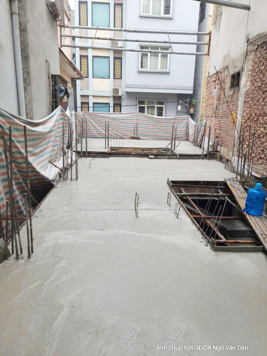 Công trường thi công phần thô, nhìn từ trên cao xuống khu vực sàn tầng. Sàn đã được đổ bê tông một phần, các lỗ thông tầng…