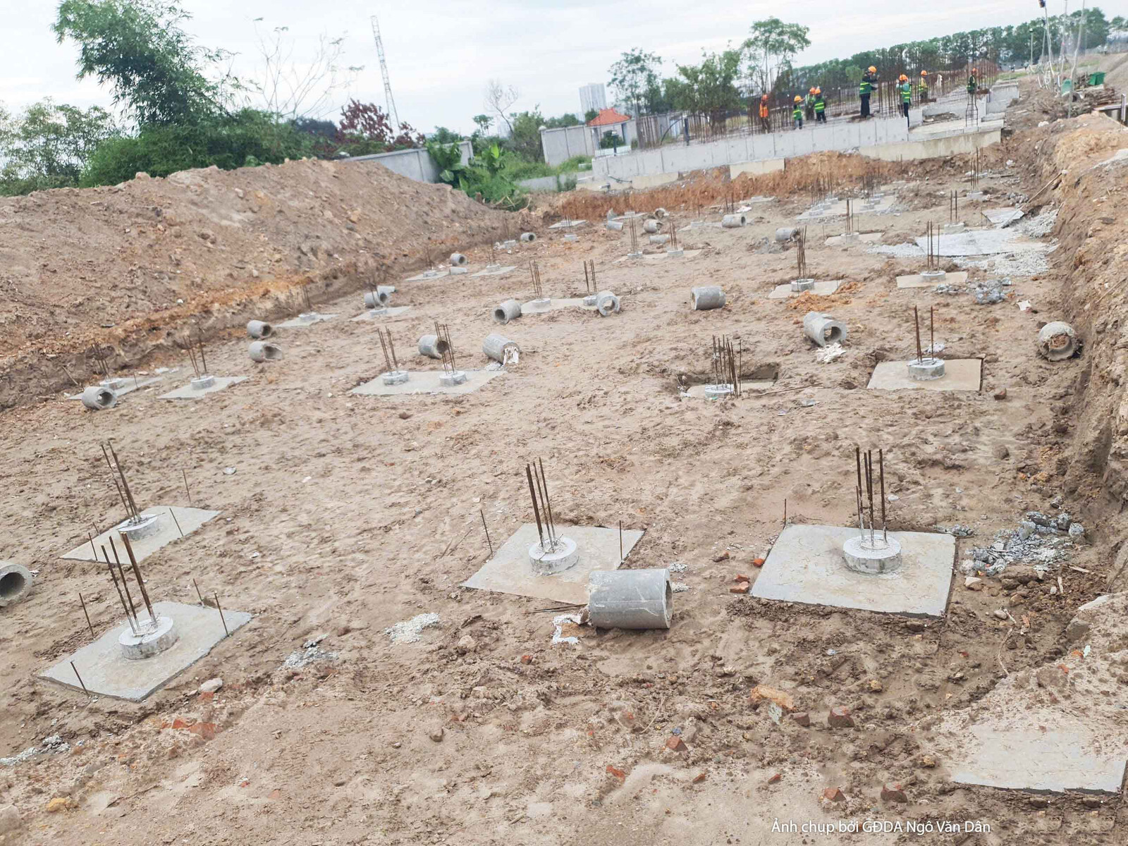 Khu vực thi công móng cọc và đài móng đã hoàn thiện một phần. Các đài móng bê tông đã được đổ, với hệ thép chờ vươn lên, s…
