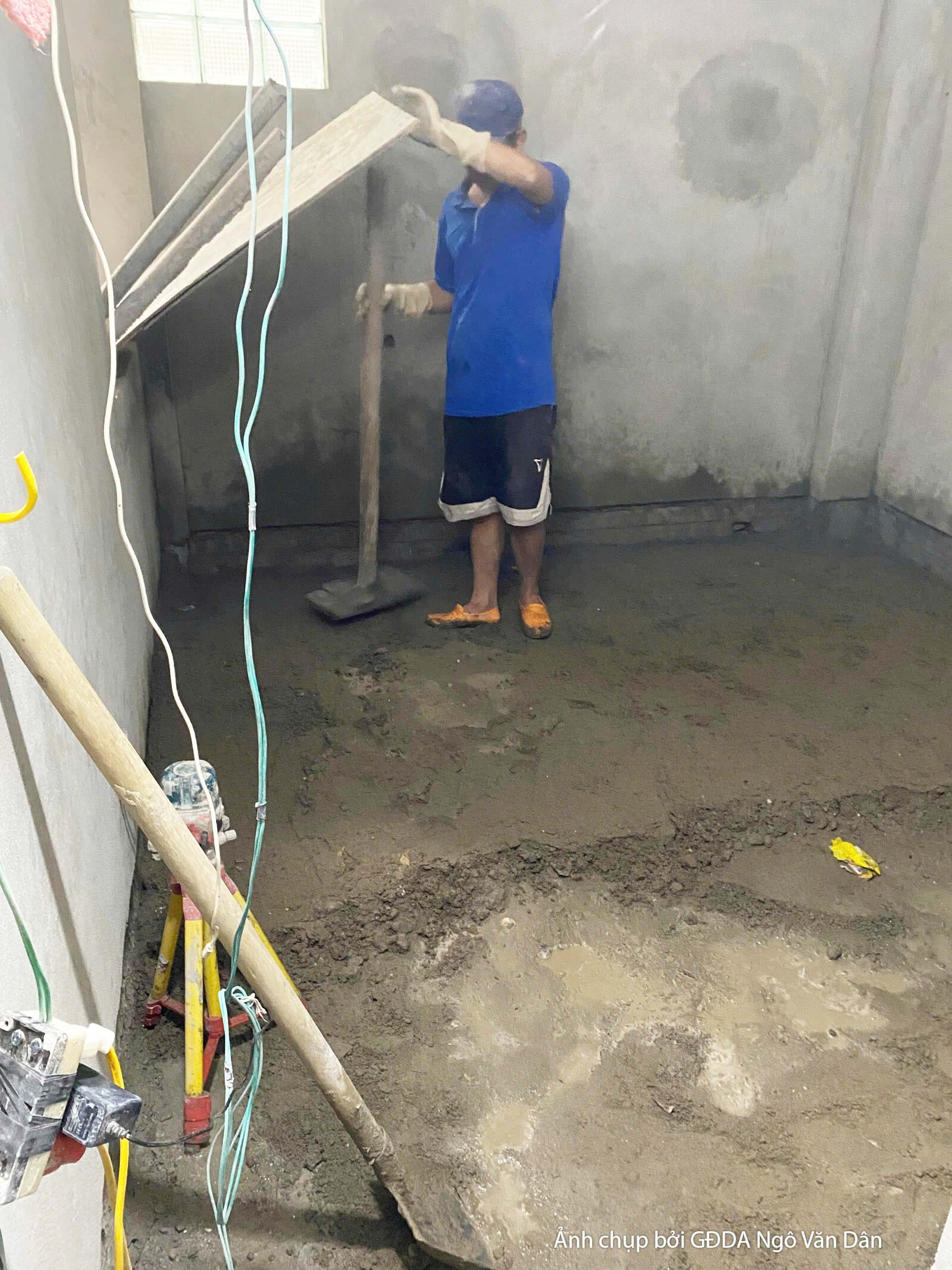 Công nhân đang san phẳng nền nhà bằng bay, chuẩn bị cho việc lát sàn hoặc các công đoạn hoàn thiện tiếp theo. Nền nhà còn…