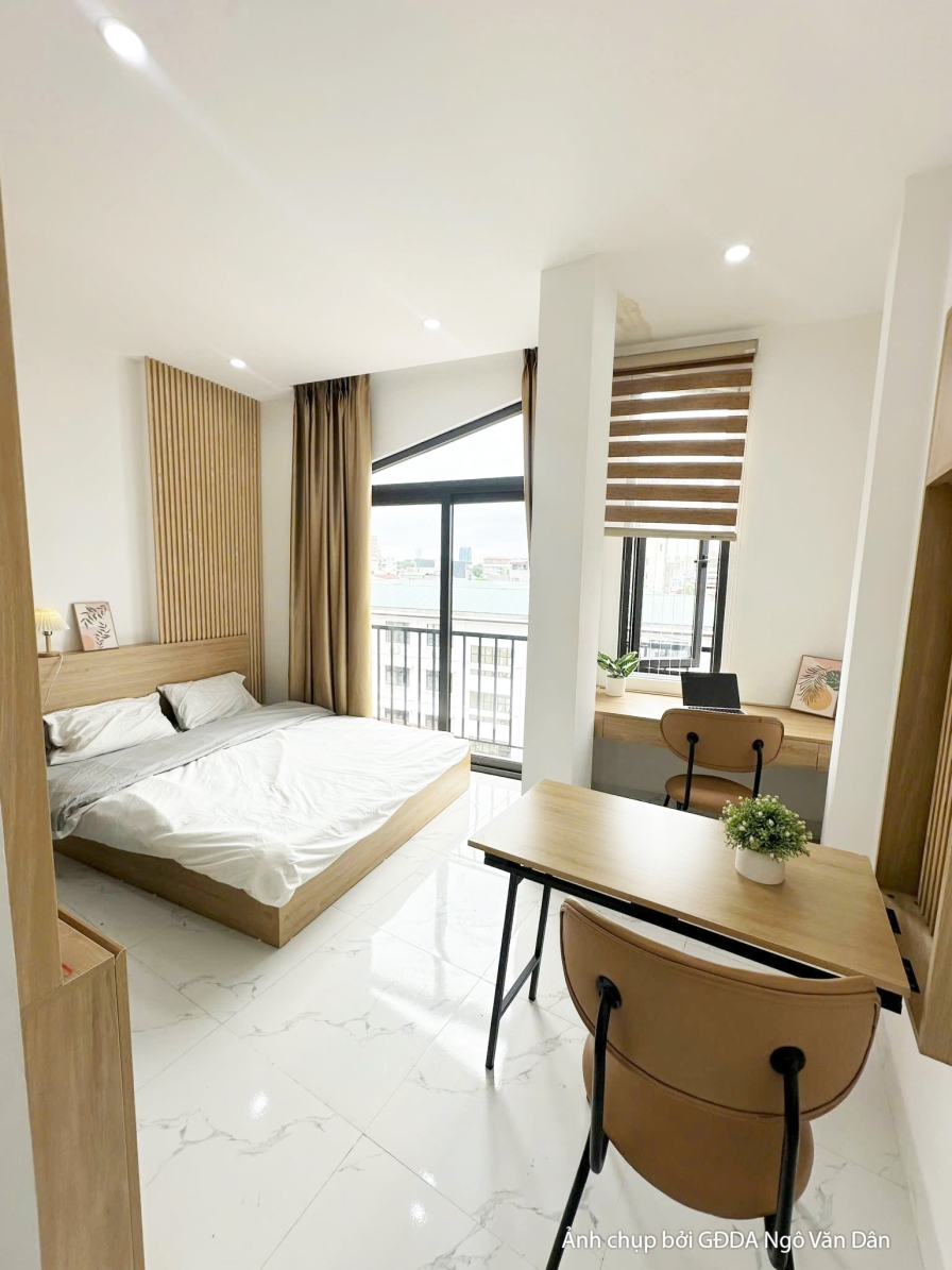 Toàn cảnh phòng ngủ đã hoàn thiện với giường thấp, bàn làm việc nhỏ và tủ quần áo âm tường. Sàn gạch sáng màu vân đá, trần…