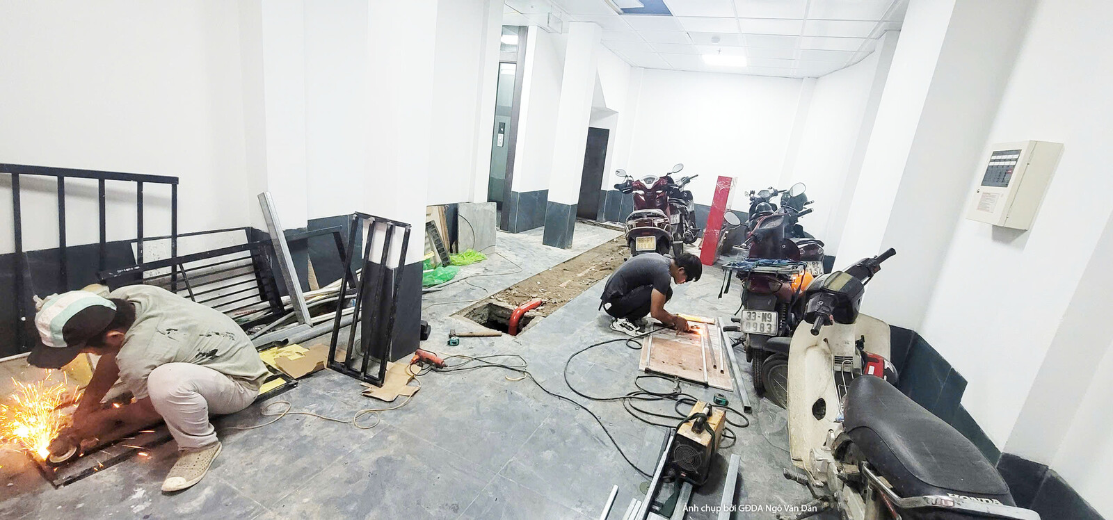 Không gian căn hộ rộng đang trong giai đoạn lắp đặt nội thất, sàn nhà được bảo vệ bằng bạt. Nhiều vật liệu, thiết bị và dụ…