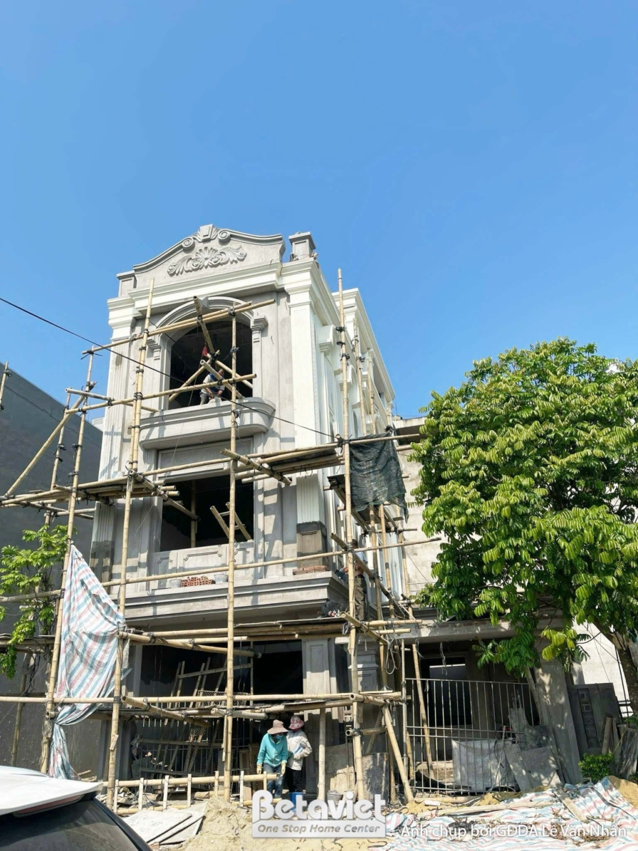 Góc nhìn tổng thể nhà phố 3 tầng tân cổ điển đang xây dựng phần thô, dưới ánh nắng ban ngày. Công trình hiện rõ hình khối…