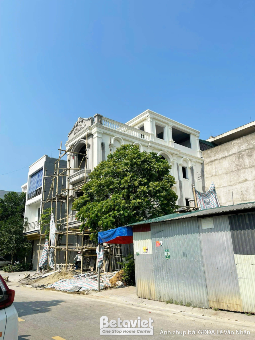 Góc nhìn nghiêng của nhà phố 3 tầng tân cổ điển đang thi công phần thô, cho thấy chiều sâu và quy mô công trình. Phần mặt…