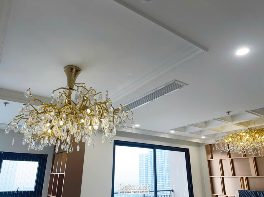 Cận cảnh trần thạch cao phẳng mịn với hệ thống đèn downlight âm trần và khe điều hòa âm trần tinh tế. Đèn chùm pha lê lớn…
