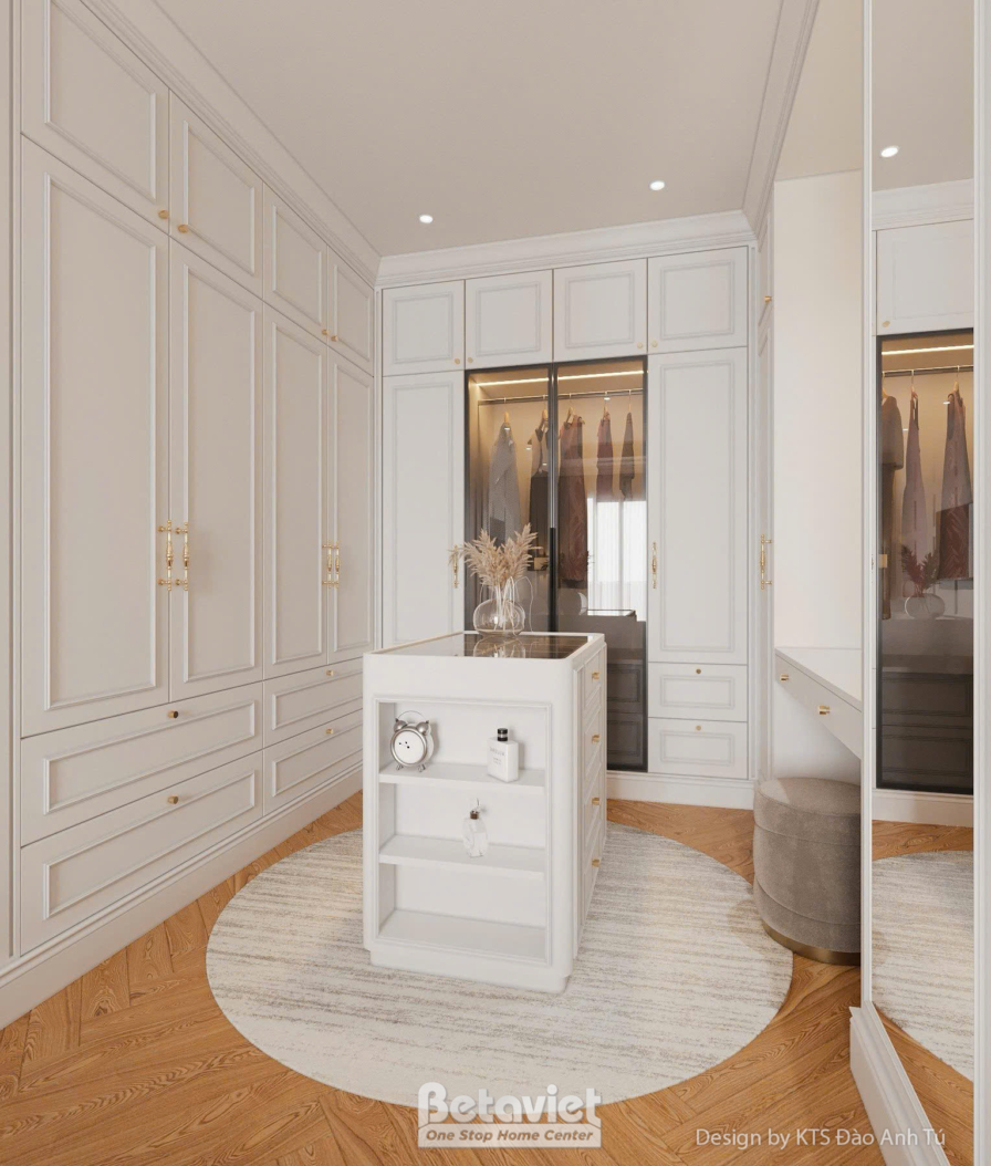 Phòng thay đồ dạng walk-in closet với tủ áo cửa gương, đảo tủ trắng hình tròn ở trung tâm, sàn gỗ tự nhiên, ánh sáng dịu n…
