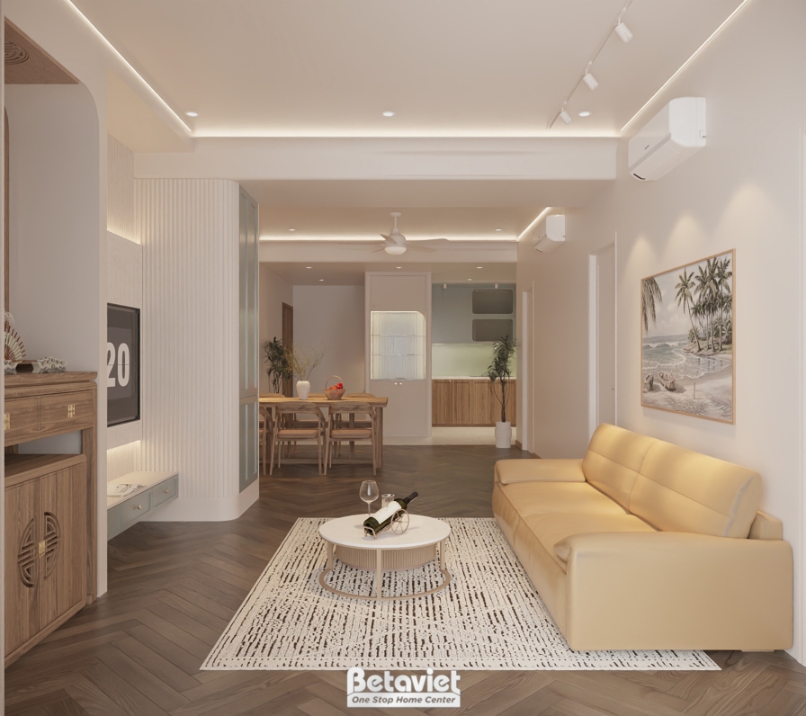 Phối cảnh phòng khách tối giản tông be, sofa be, thảm hoạ tiết nhạt, sàn gỗ xương cá và bếp phía sau