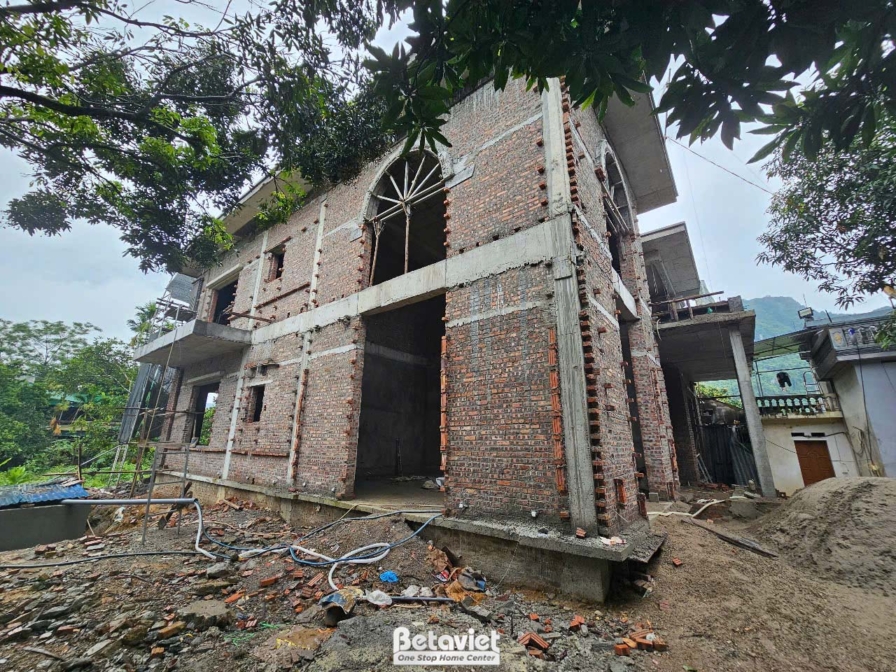 Góc nhìn từ xa của công trình biệt thự đang trong giai đoạn xây tường gạch, với các khung cửa sổ và cửa chính đã định hình…