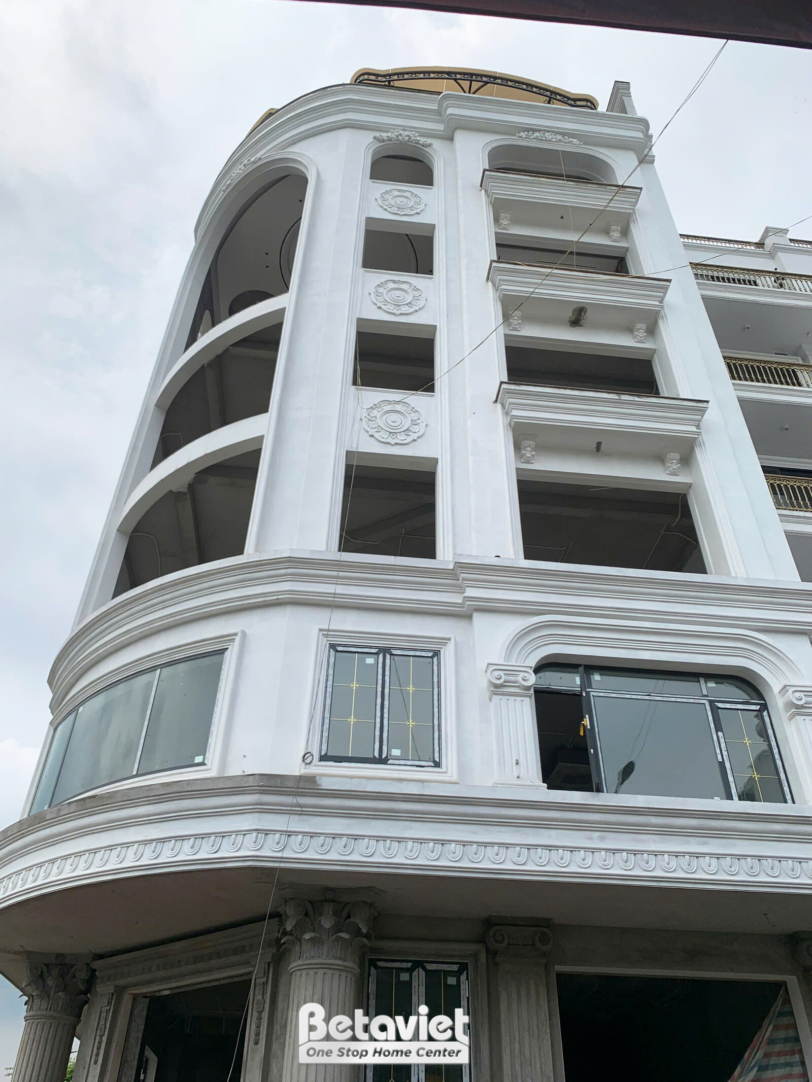 Cận cảnh mặt tiền tòa nhà văn phòng nhiều tầng, tập trung vào các chi tiết kiến trúc tân cổ điển như phào chỉ, gờ tường và…