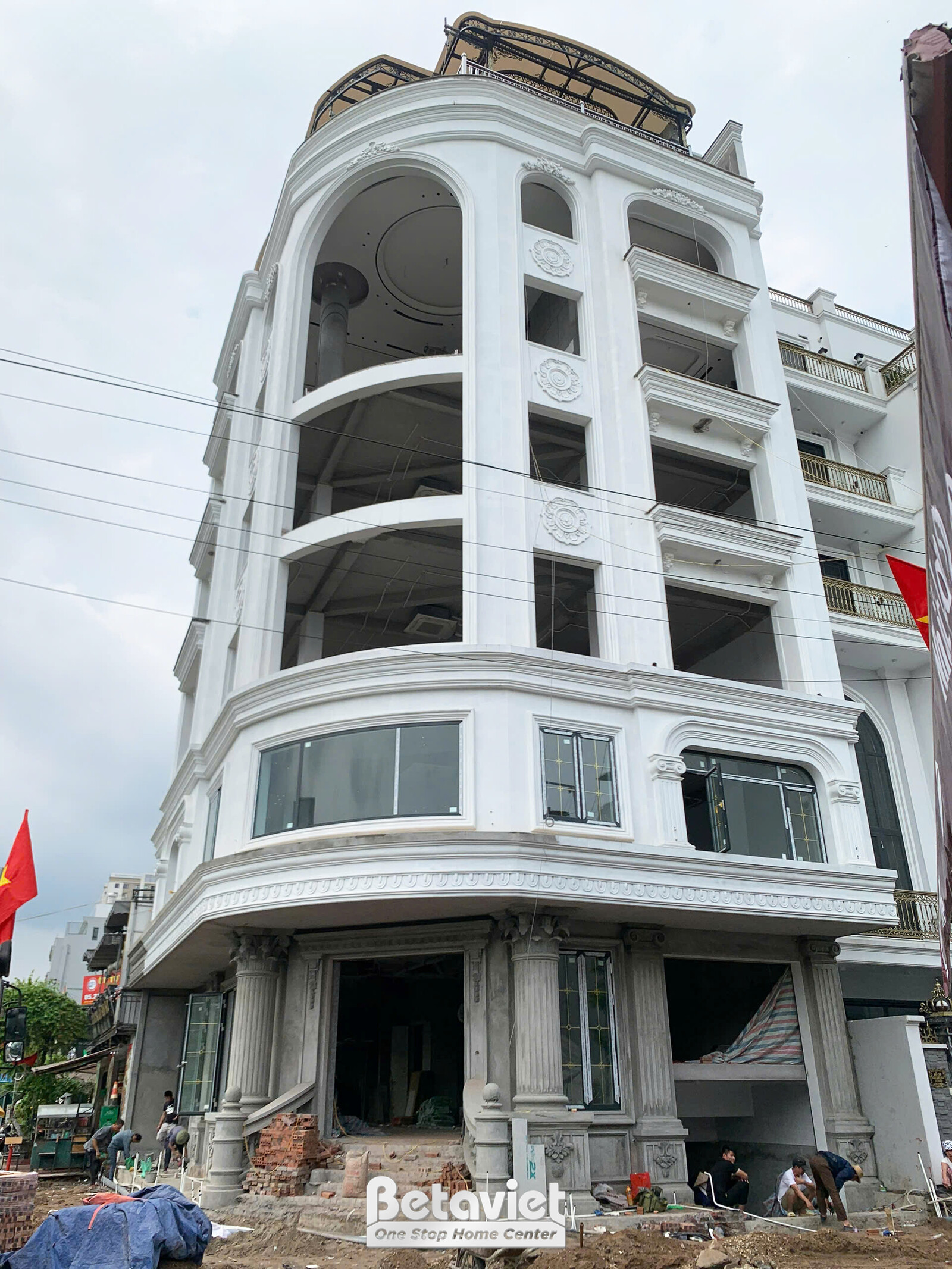 Góc nhìn trực diện tòa nhà văn phòng TC2600127 đang thi công phần thô, với công nhân đang làm việc ở tầng trệt. Mặt tiền b…