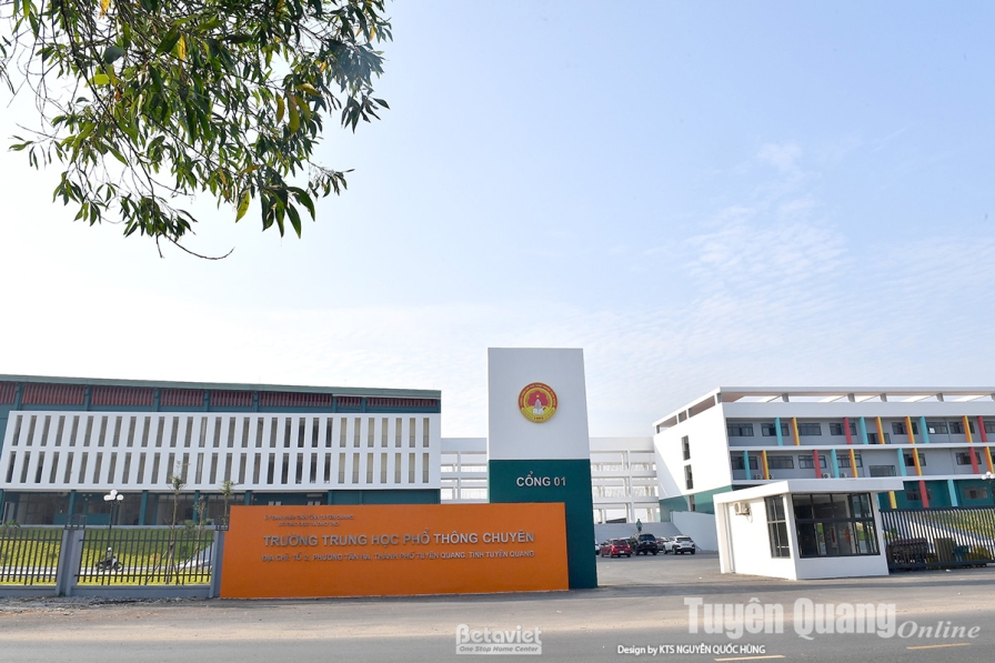 Ảnh cổng chính công trình với biển Cổng 1 và bảng tên Trường Trung học phổ thông Chuyên nền cam, cột biểu tượng gắn quốc h…