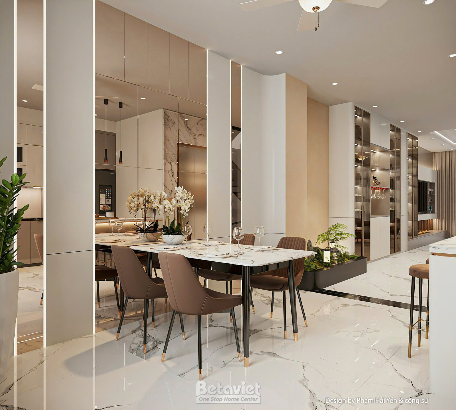 Khu vực bàn ăn liền kề bếp với bàn đá mặt trắng, ghế bọc nệm nâu, đèn thả trần dáng mảnh, mảng đá ốp tường điểm nhấn, kệ t…