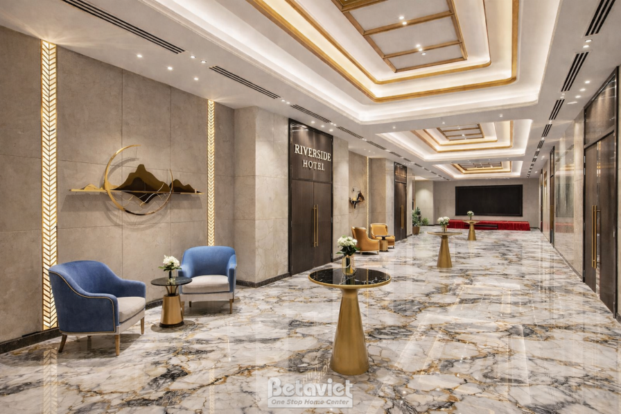 Sảnh chờ tiền phòng hội nghị, sàn đá marble vân xám trắng bóng loáng, ghế bành xanh navy, bàn tròn chân đồng, vách trang t…